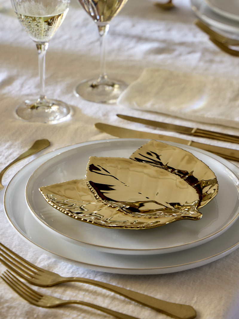Aporte un toque de brillo a su mesa con piezas de gres COSTA NOVA en tonos dorados y detalles sofisticados — perfectas para completar la decoración navideña.