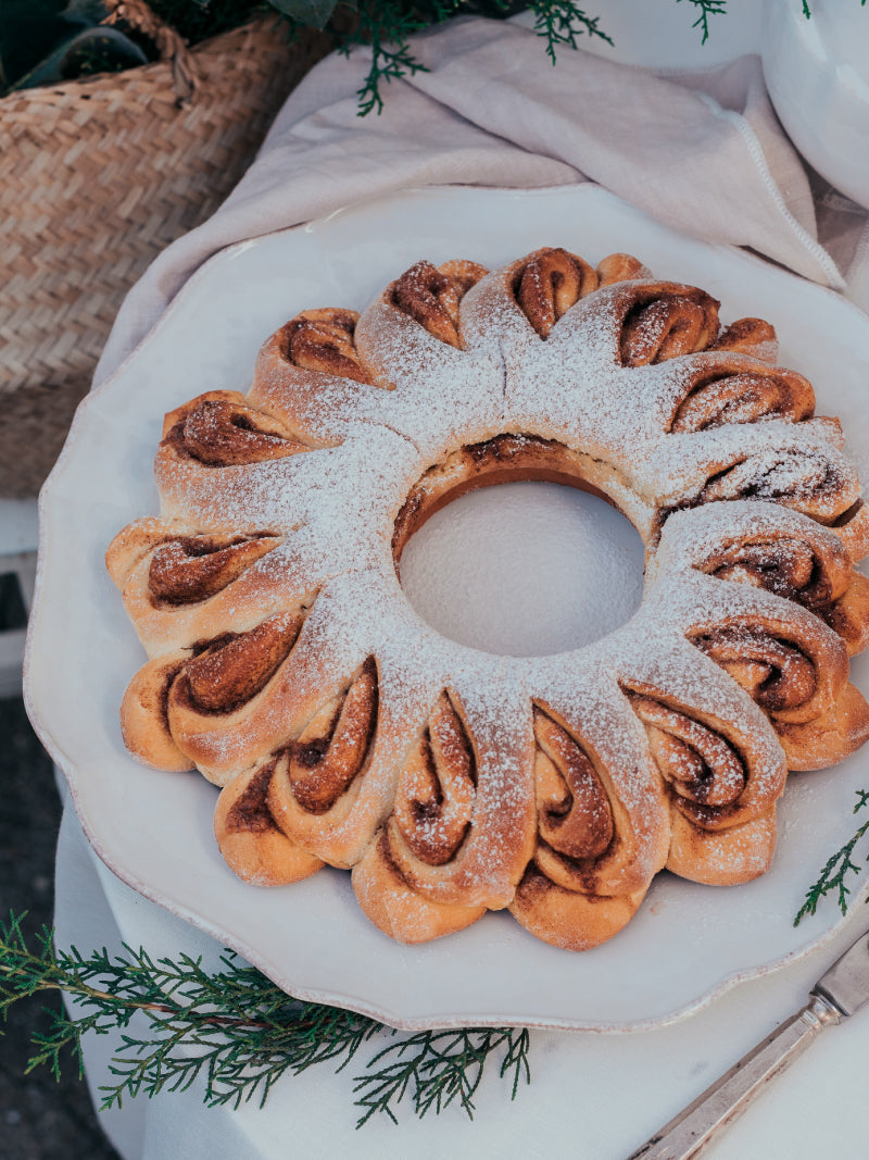 Pan dulce en forma de corona con canela y cardamomo, ideal para el desayuno o la merienda de Navidad. Una receta acogedora para servir en vajilla COSTA NOVA.